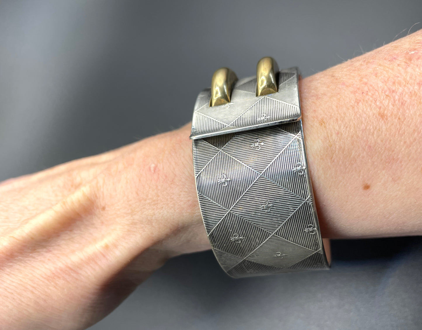 Vintage signed Kigu Art Deco engine turned machine age gold and silver tone wide bangle bracelet hinged cuff, fleur de lys Bauhaus design