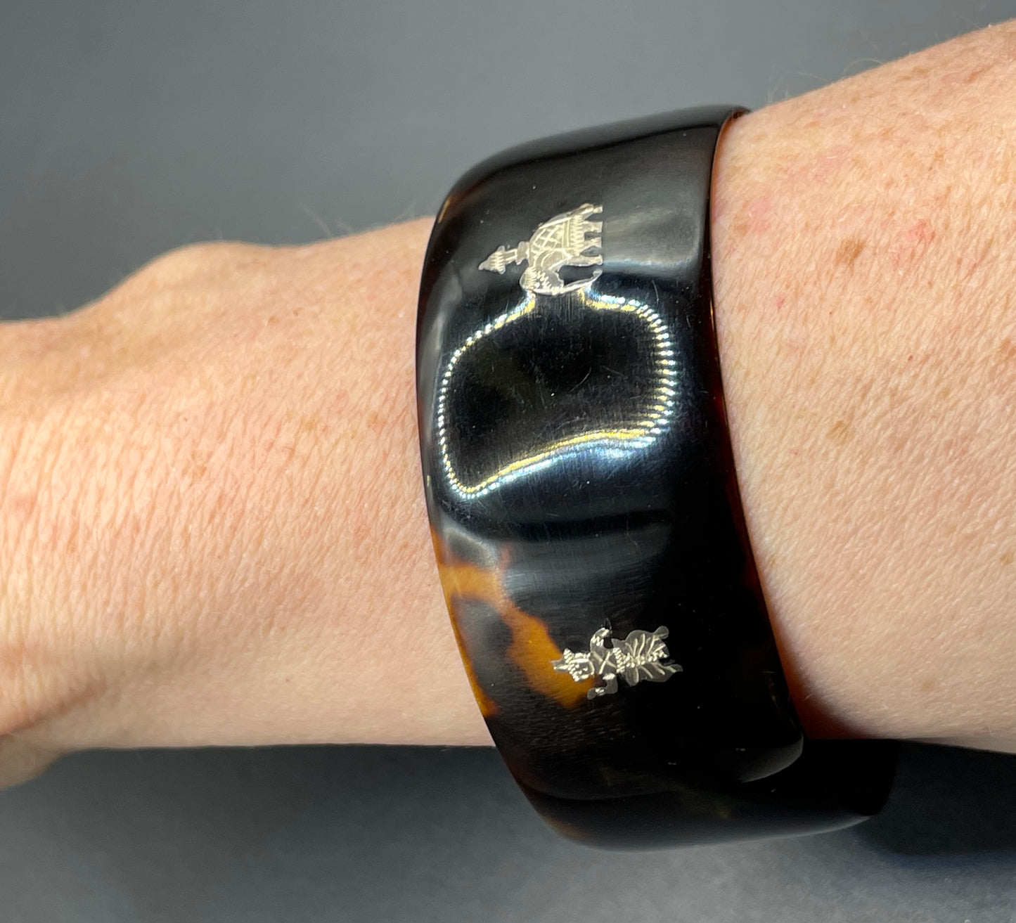 Antique tortoiseshell and silver piqué work bangle, perhaps souvenir of South Asia, figures and an elephant depicted