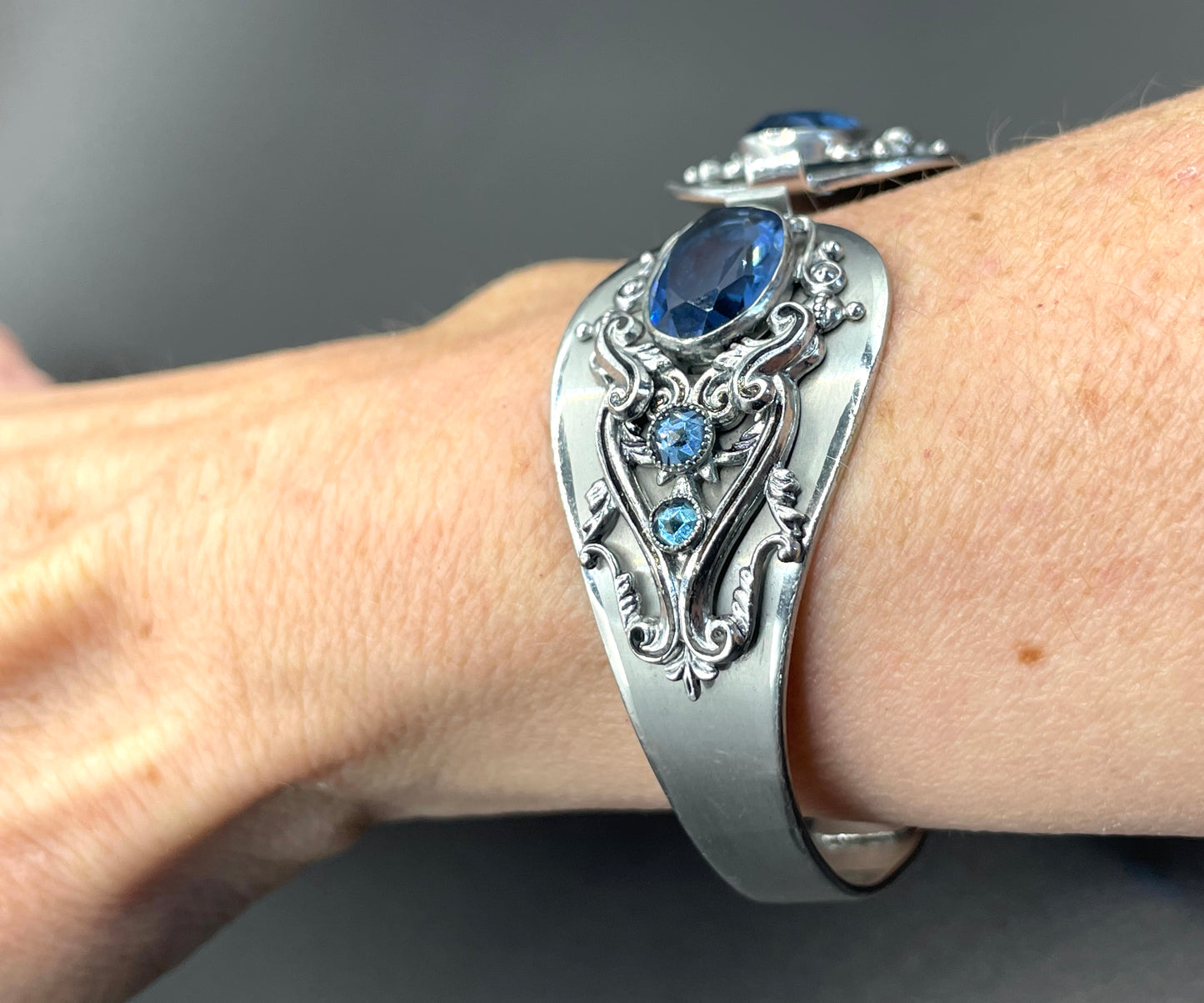 Vintage Neiger brothers sapphire blue rhinestone ornate Art Deco hinged clamper bangle set in silver tone with black enamel accents