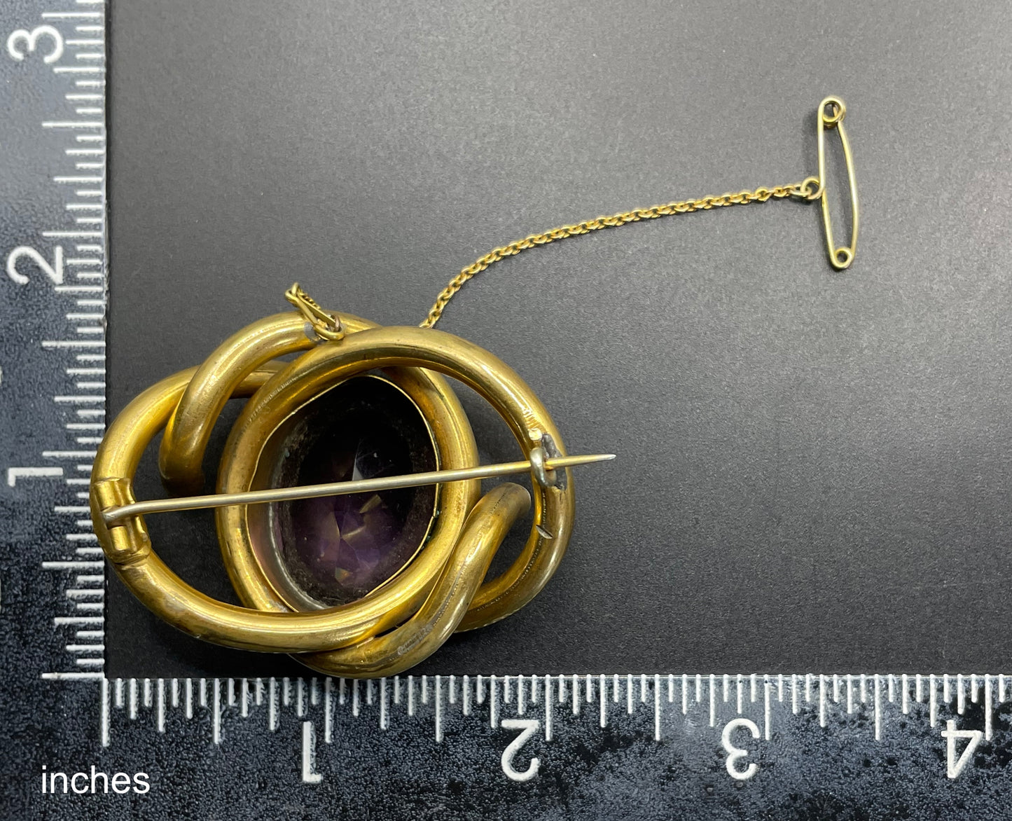Antique Victorian Scottish chased pinchbeck or gold filled / rolled gold large love knot brooch with large purple paste rhinestone