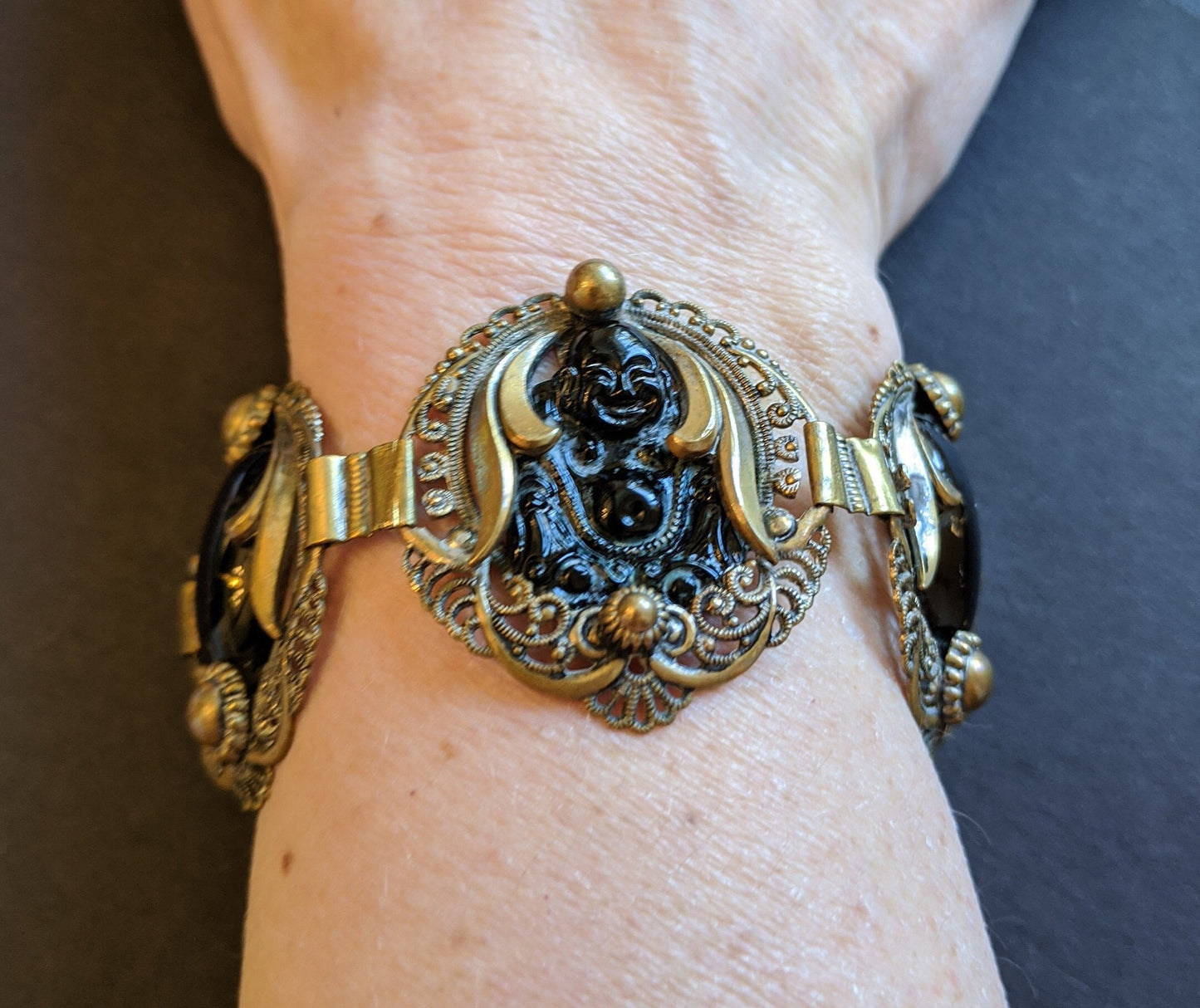 Vintage Art Deco Buddha bracelet black moulded glass cabochon & gold tone filigree panel cuff bracelet - unsigned Joseff of Hollywood?