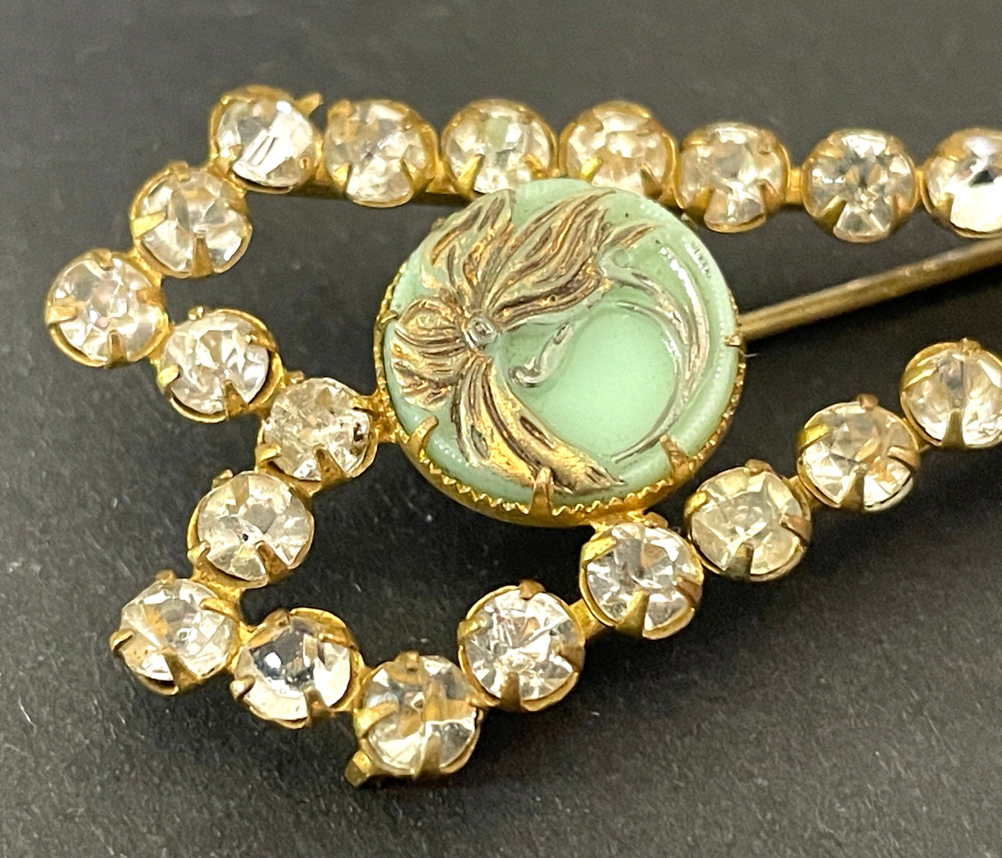 Huge vintage paste brooch, clear rhinestones with moulded green glass floral discs, gold tone closed cup settings, Deco geometric bow design