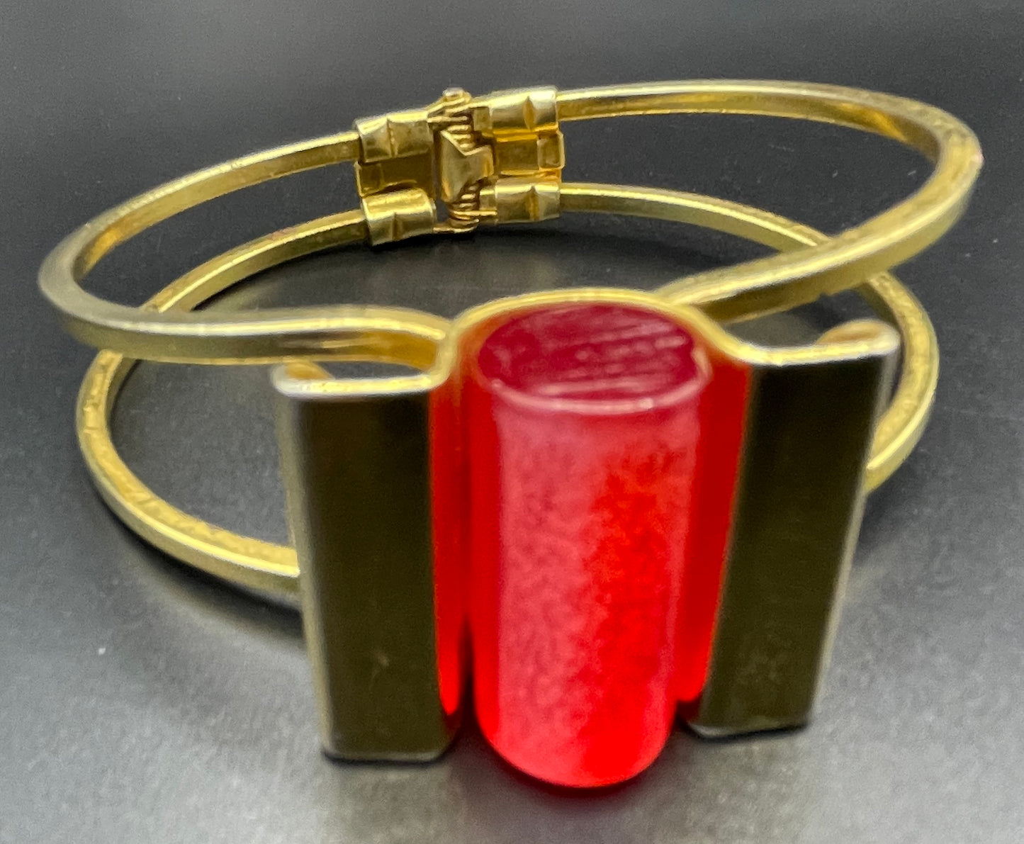 Vintage Jakob Bengel Art Deco machine age clamper bangle in shiny gold tone with a rich orange galalith cylinder