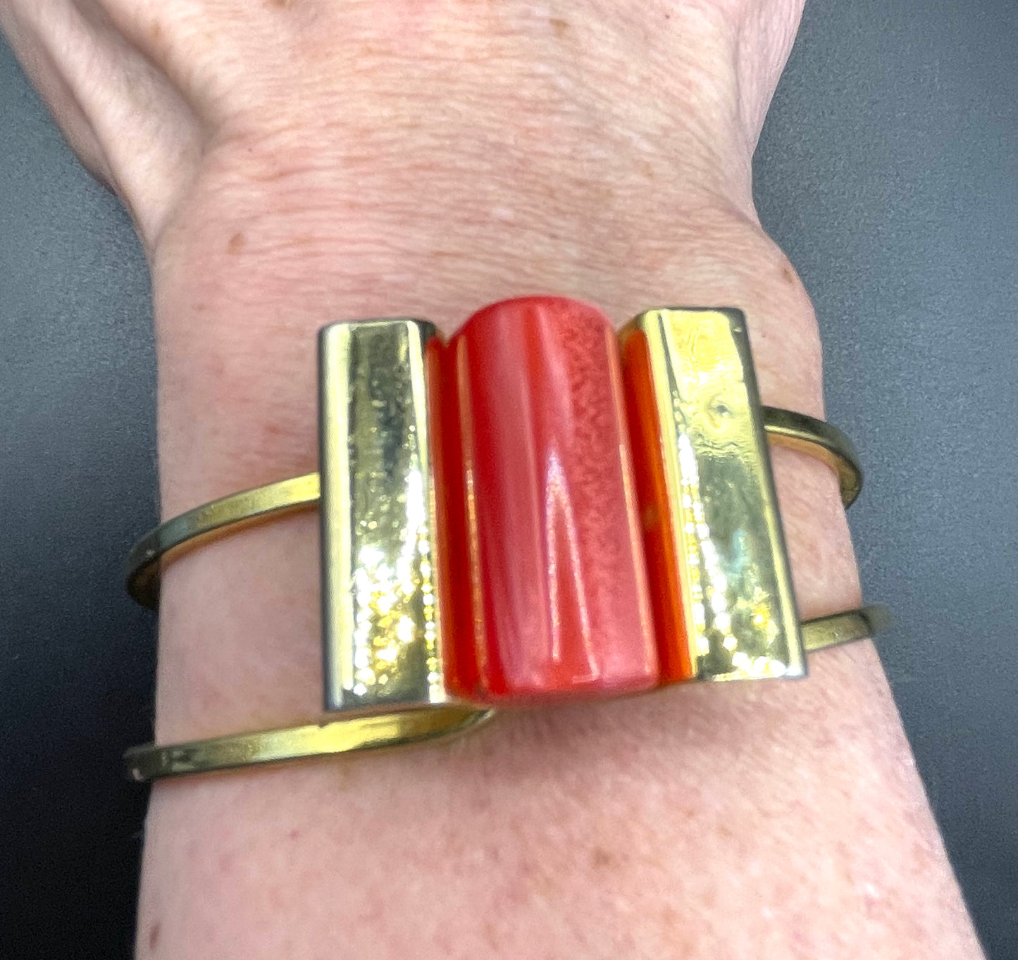 Vintage Jakob Bengel Art Deco machine age clamper bangle in shiny gold tone with a rich orange galalith cylinder