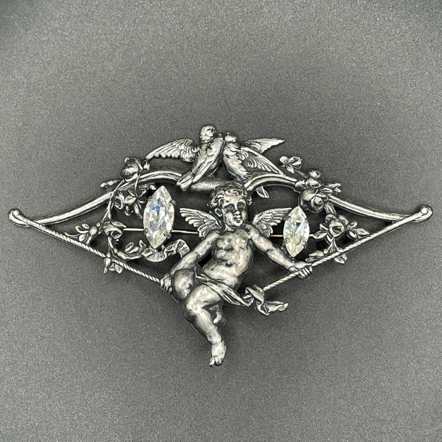 Large early Askew London, vintage cupid brooch in antique silver tone with marquise cut clear rhinestones, cherub / putti & love bird design