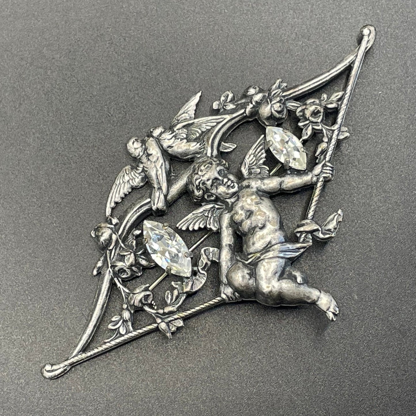 Large early Askew London, vintage cupid brooch in antique silver tone with marquise cut clear rhinestones, cherub / putti & love bird design