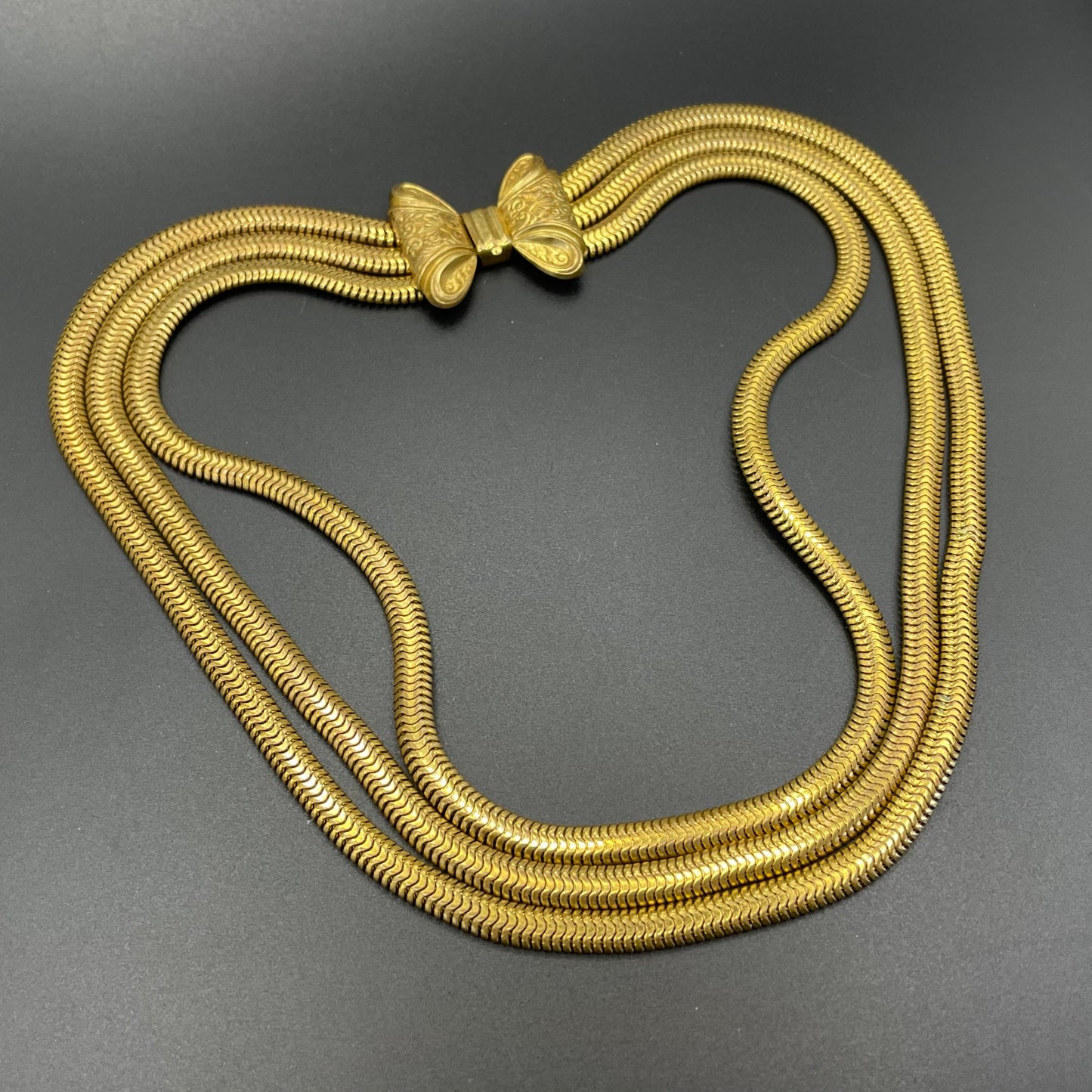 Vintage Art Deco machine age repousse bow clasp triple strand thick gold tone snake chain necklace