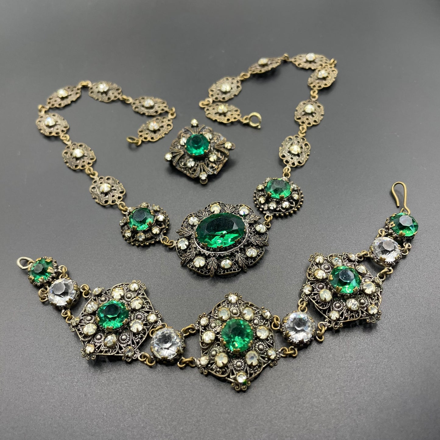 Vintage Art Deco Czech emerald green and clear glass rhinestone and gold tone filigree necklace, bracelet and brooch set, possibly Neiger