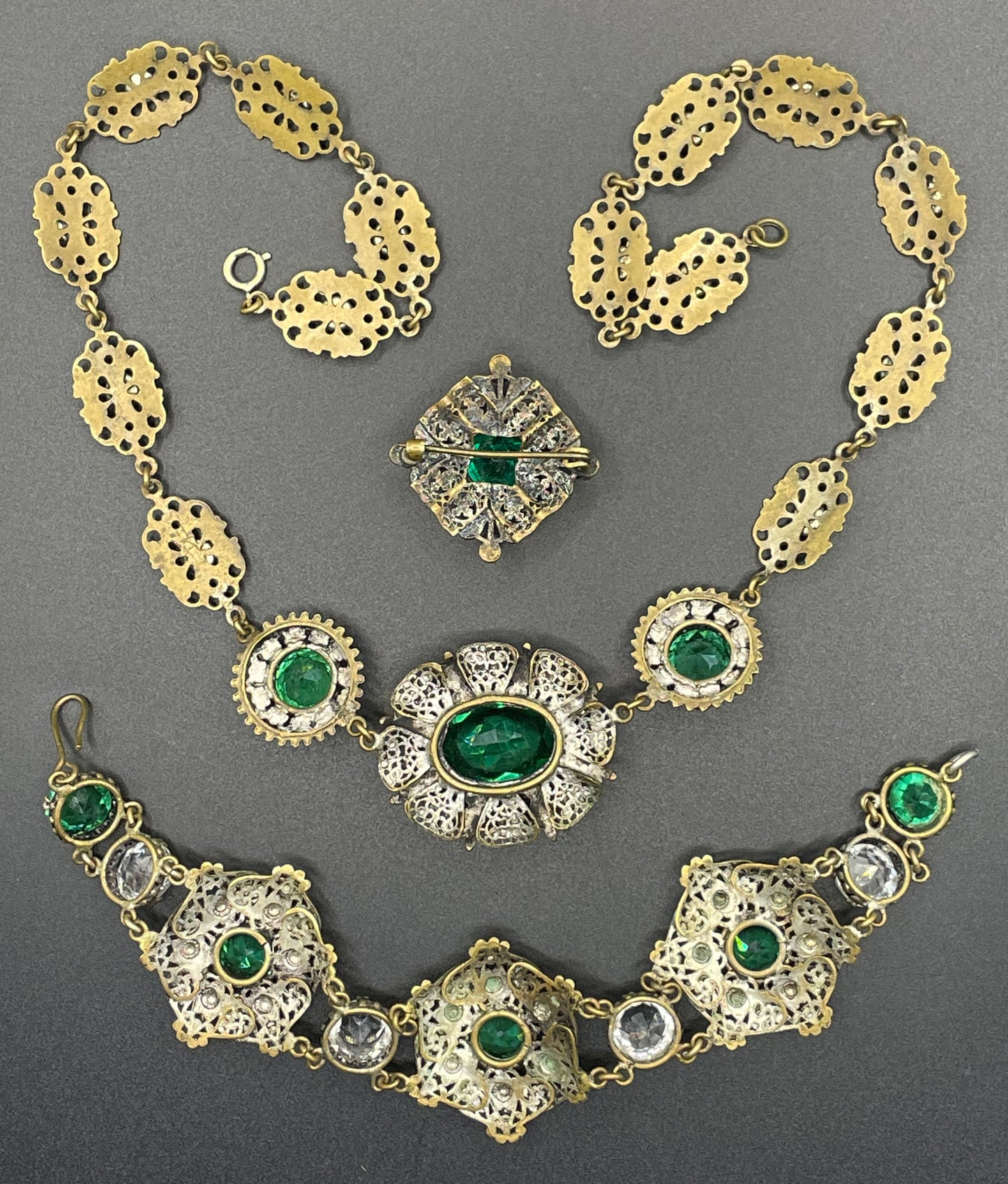 Vintage Art Deco Czech emerald green and clear glass rhinestone and gold tone filigree necklace, bracelet and brooch set, possibly Neiger