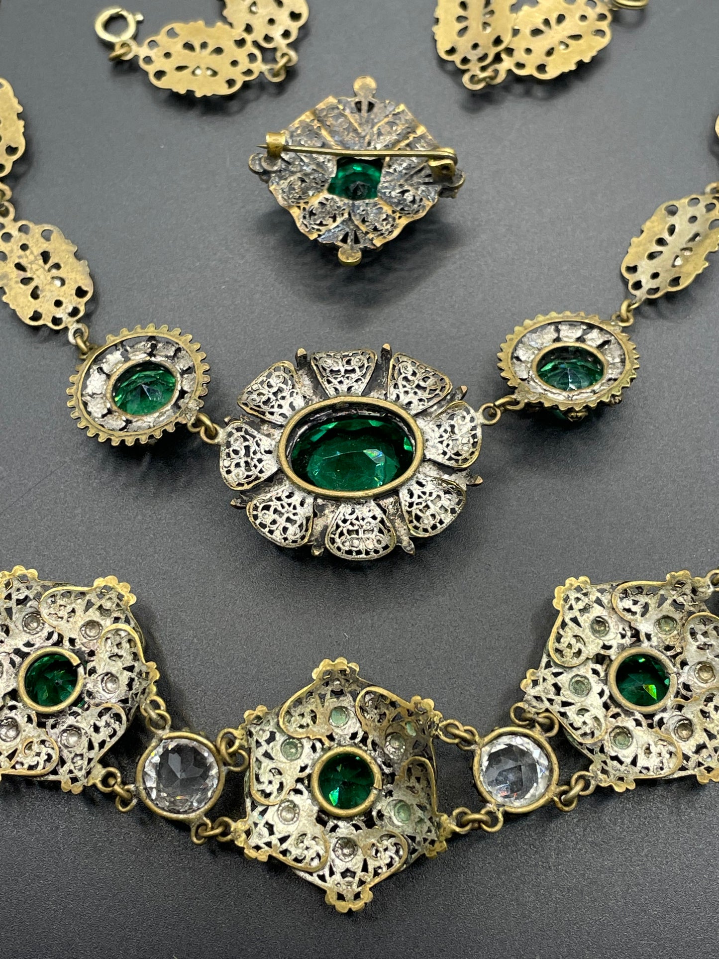 Vintage Art Deco Czech emerald green and clear glass rhinestone and gold tone filigree necklace, bracelet and brooch set, possibly Neiger