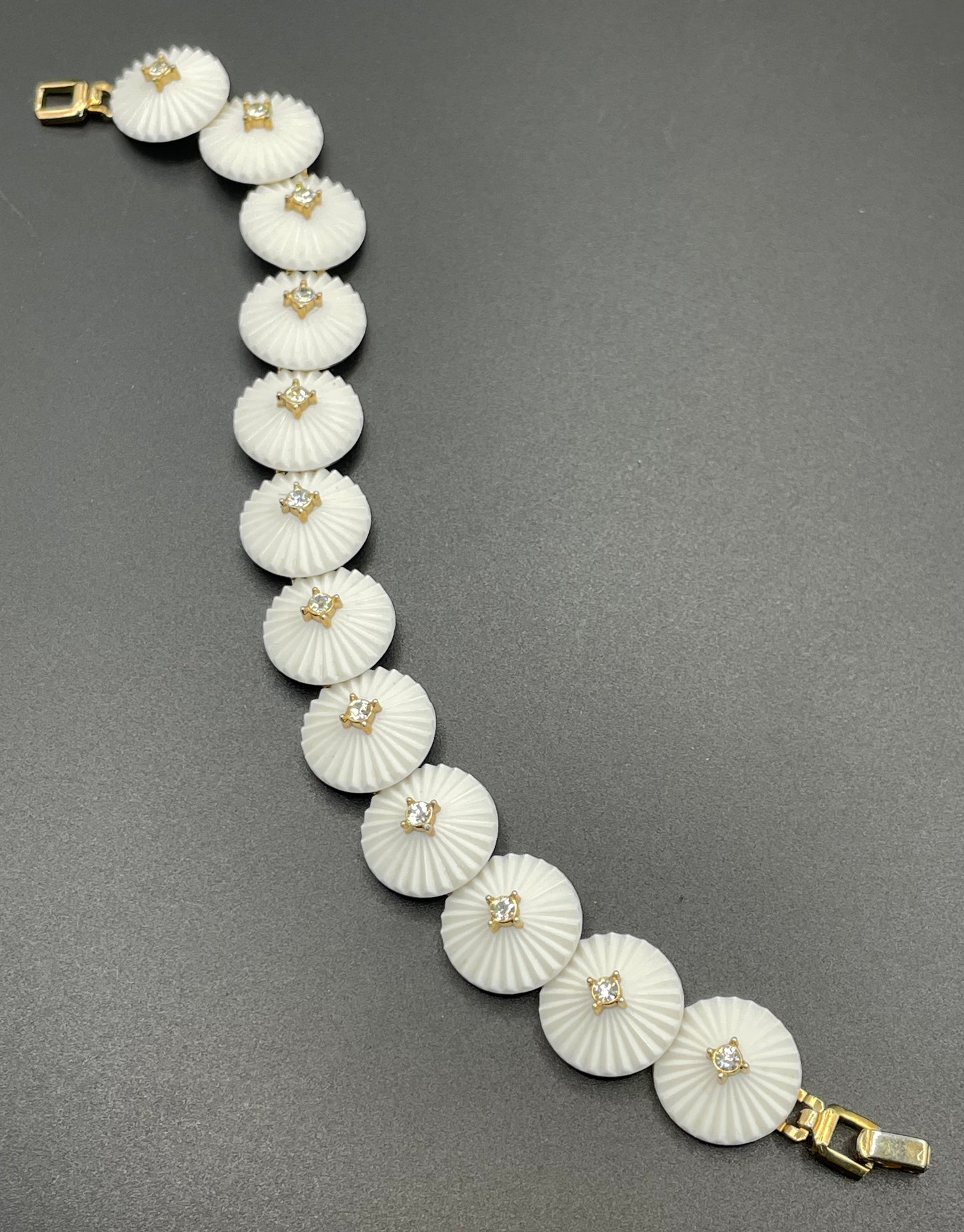 Vintage signed Trifari white celluloid plastic, clear rhinestone and gold tone panel bracelet and clip on earrings set, 1960s