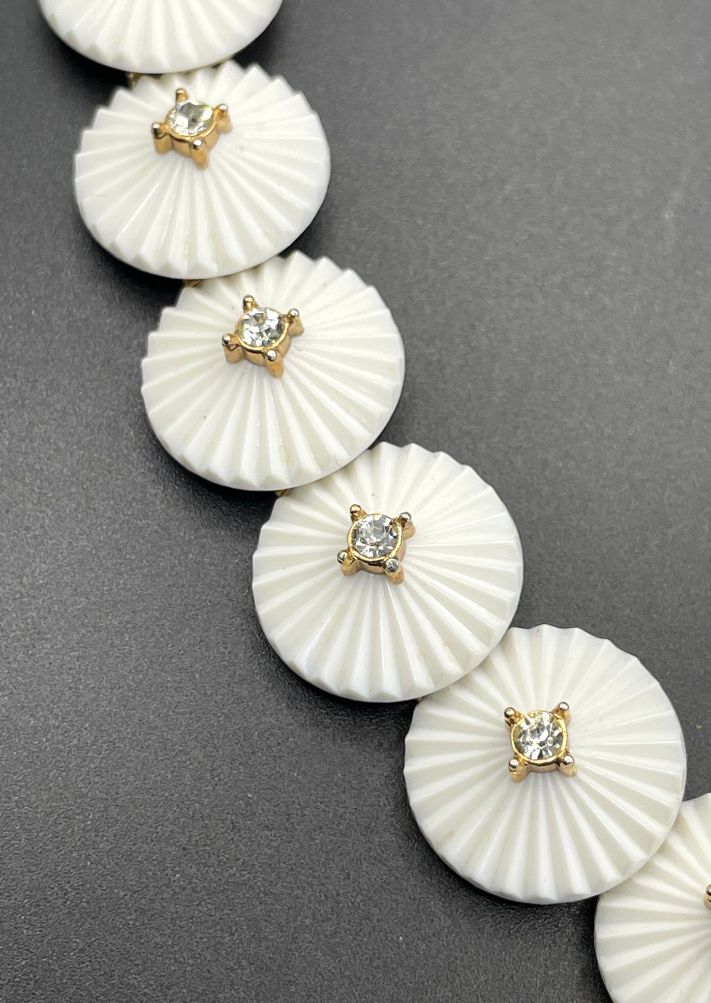 Vintage signed Trifari white celluloid plastic, clear rhinestone and gold tone panel bracelet and clip on earrings set, 1960s