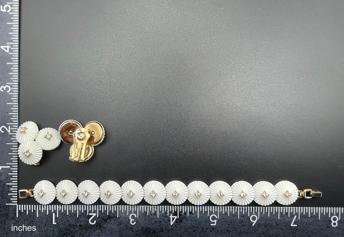 Vintage signed Trifari white celluloid plastic, clear rhinestone and gold tone panel bracelet and clip on earrings set, 1960s