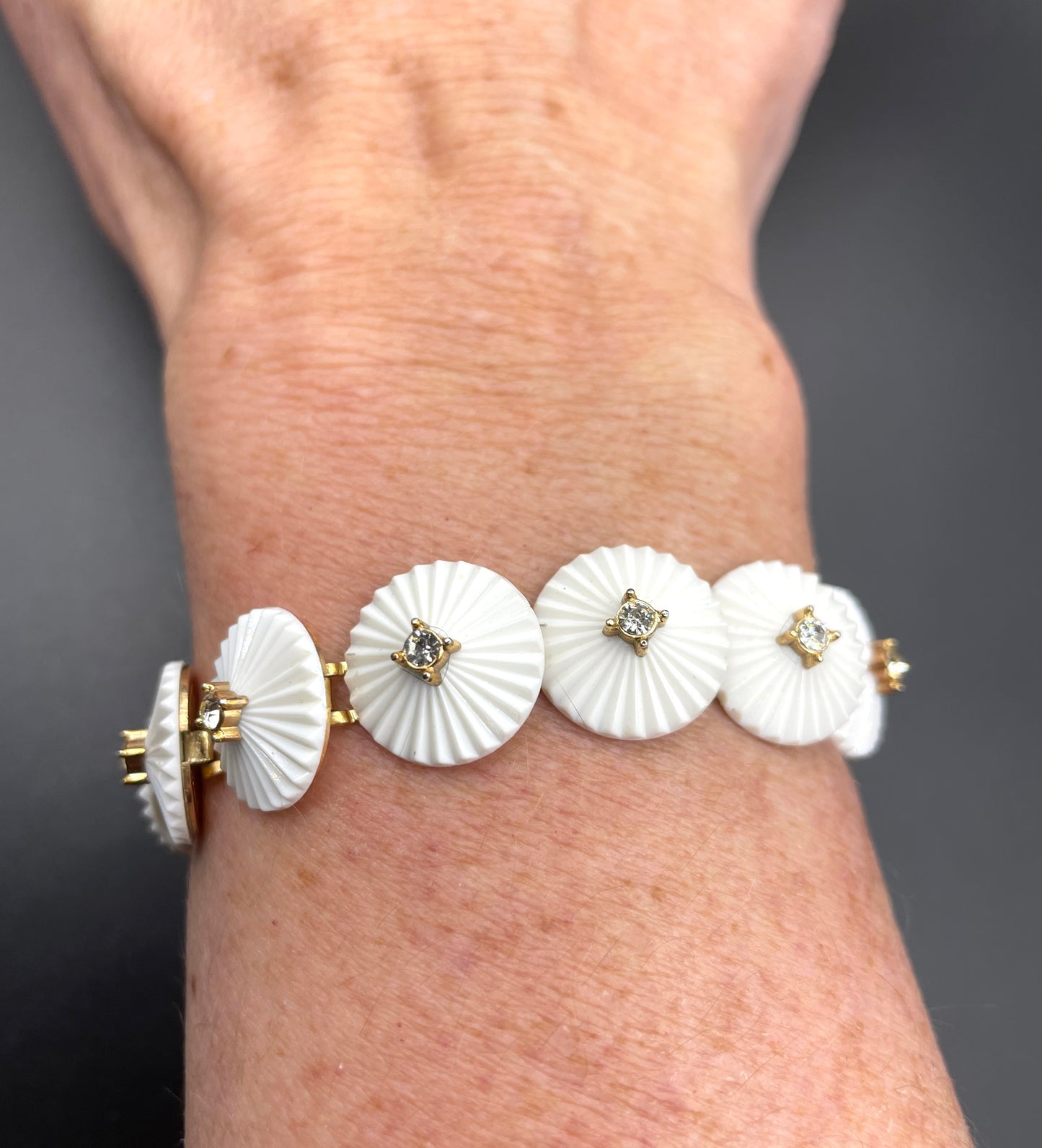 Vintage signed Trifari white celluloid plastic, clear rhinestone and gold tone panel bracelet and clip on earrings set, 1960s