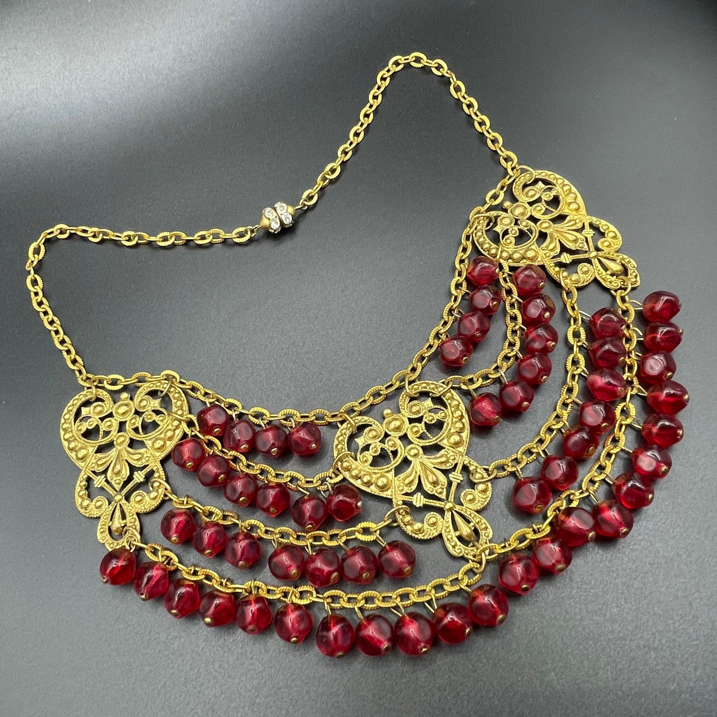 Vintage ruby red poured glass beaded festoon fringe necklace with gold tone filigree panels, French or Czech or perhaps Miriam Haskell style