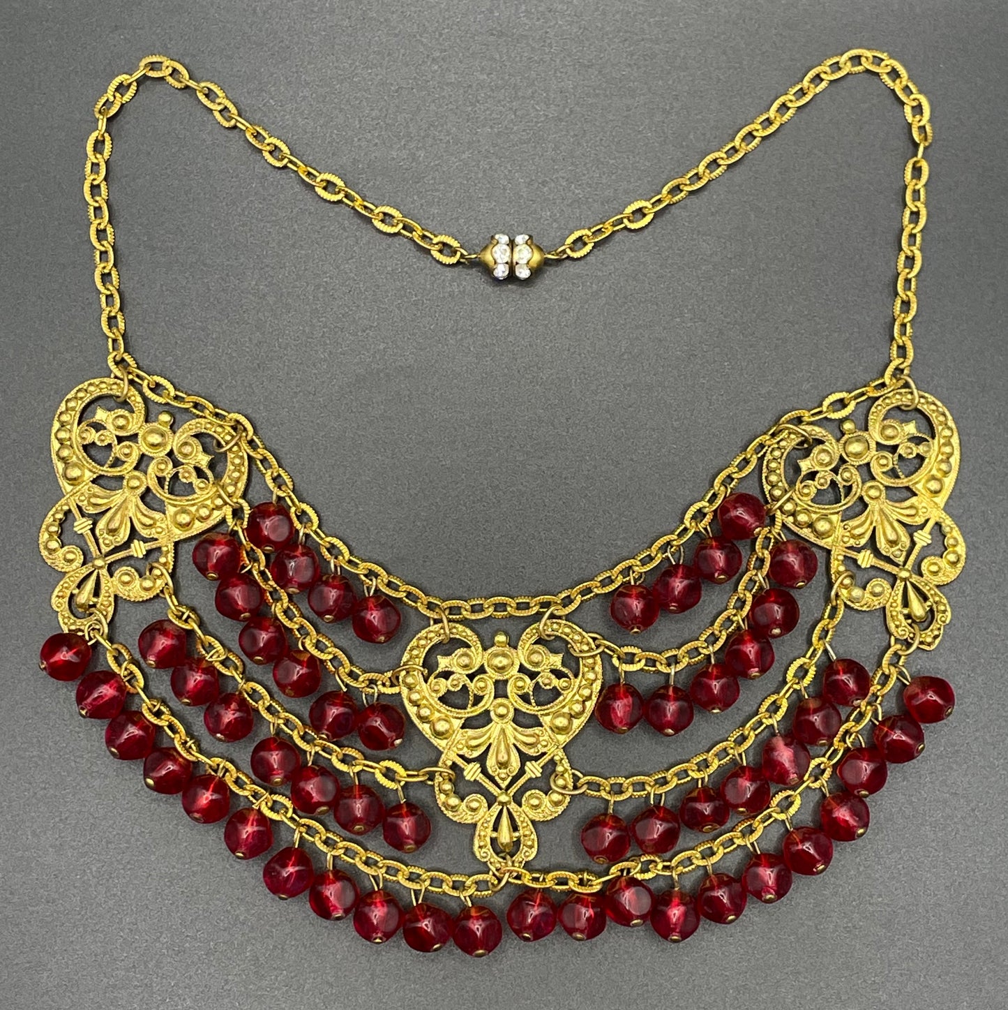 Vintage ruby red poured glass beaded festoon fringe necklace with gold tone filigree panels, French or Czech or perhaps Miriam Haskell style