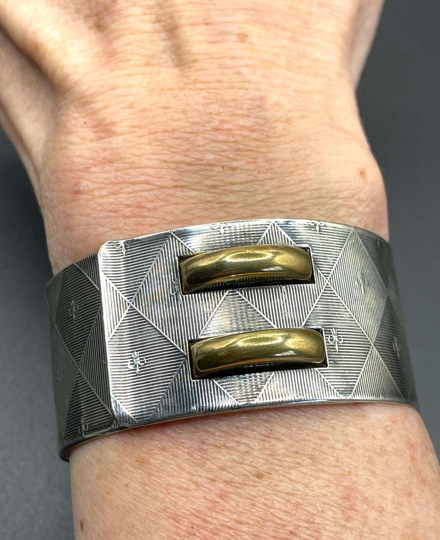 Vintage signed Kigu Art Deco engine turned machine age gold and silver tone wide bangle bracelet hinged cuff, fleur de lys Bauhaus design