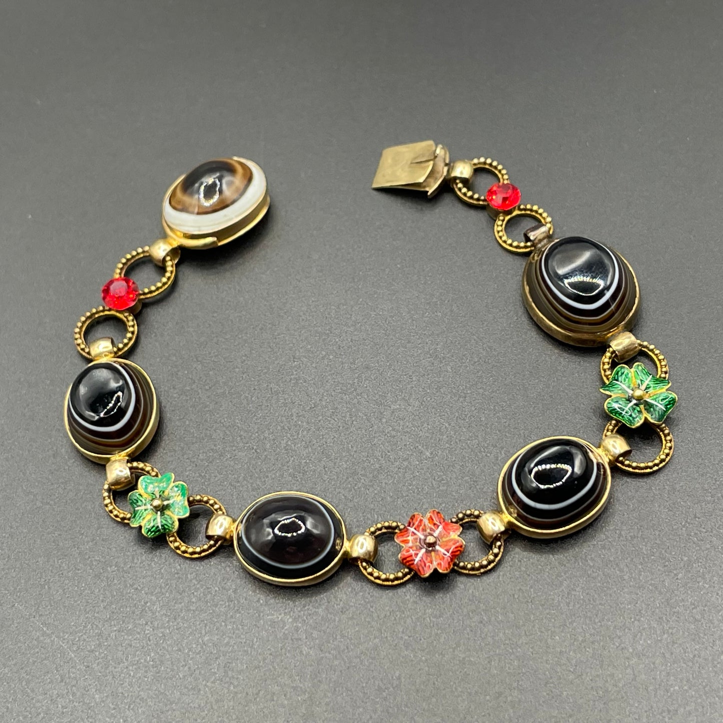 Antique Victorian unmarked 9ct gold bullseye banded agate onyx large oval cabochon, red and green enamel work flowers and red rhinestone bracelet