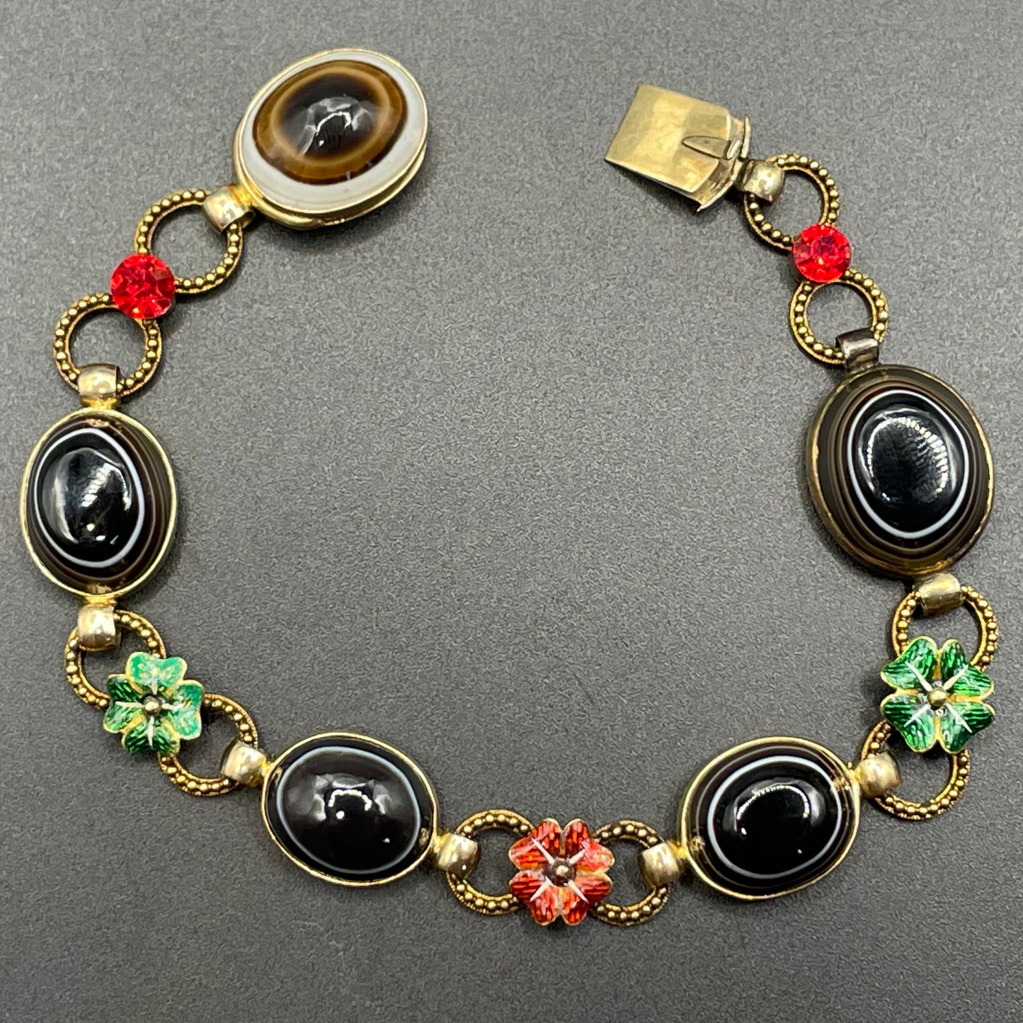 Antique Victorian unmarked 9ct gold bullseye banded agate onyx large oval cabochon, red and green enamel work flowers and red rhinestone bracelet
