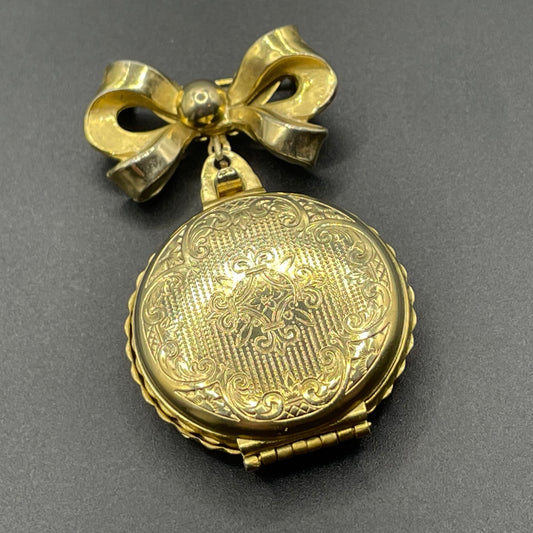 Vintage signed Coro Pegasus gold tone locket brooch, with space for several pictures, beautiful repousse detail and bow motif