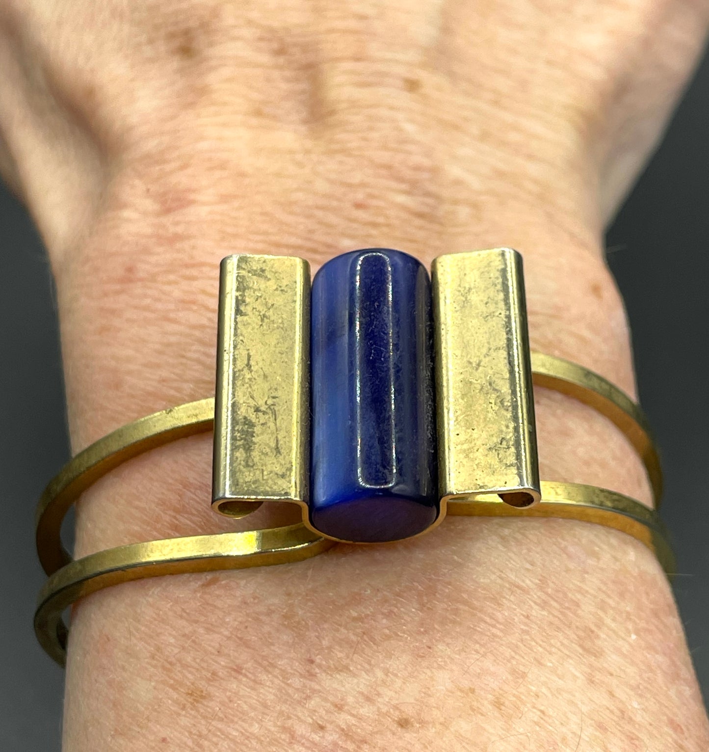 Vintage Jakob Bengel Art Deco machine age clamper bangle in shiny gold tone with a rich blue galalith cylinder