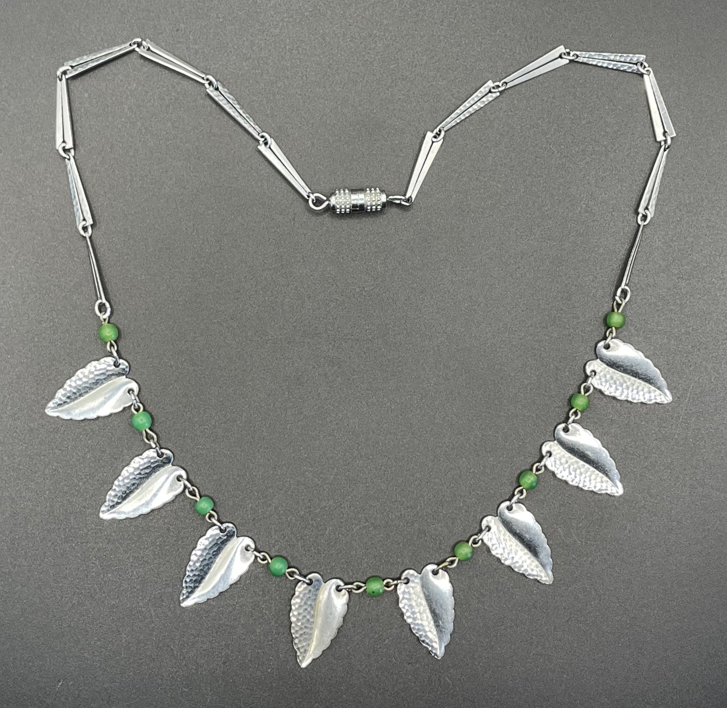Vintage Jakob Bengel Art Deco machine age necklace, bright green galalith beads with shiny and hammered silver tone chrome leaf fringe