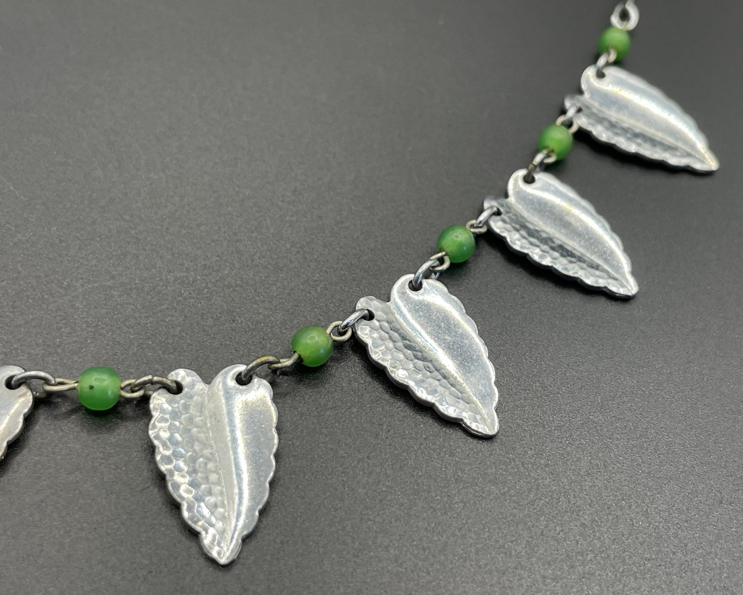 Vintage Jakob Bengel Art Deco machine age necklace, bright green galalith beads with shiny and hammered silver tone chrome leaf fringe