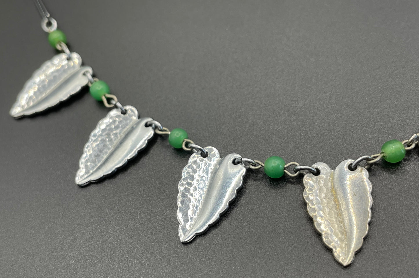 Vintage Jakob Bengel Art Deco machine age necklace, bright green galalith beads with shiny and hammered silver tone chrome leaf fringe