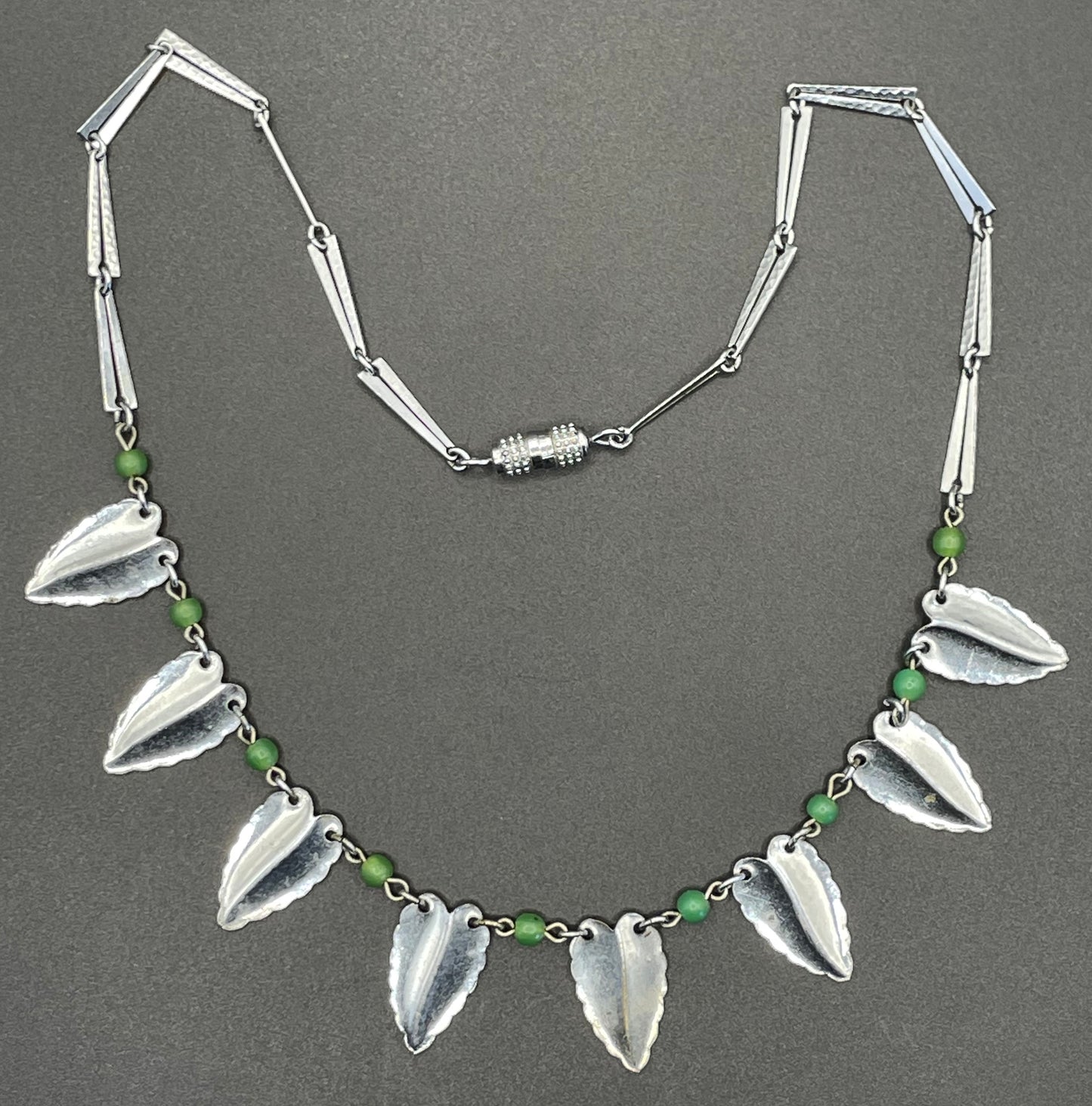 Vintage Jakob Bengel Art Deco machine age necklace, bright green galalith beads with shiny and hammered silver tone chrome leaf fringe