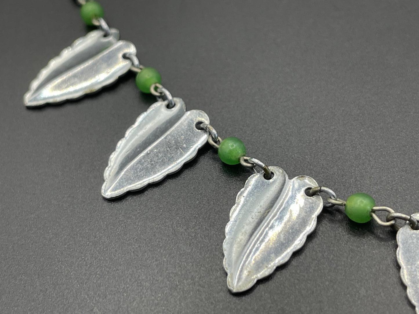 Vintage Jakob Bengel Art Deco machine age necklace, bright green galalith beads with shiny and hammered silver tone chrome leaf fringe