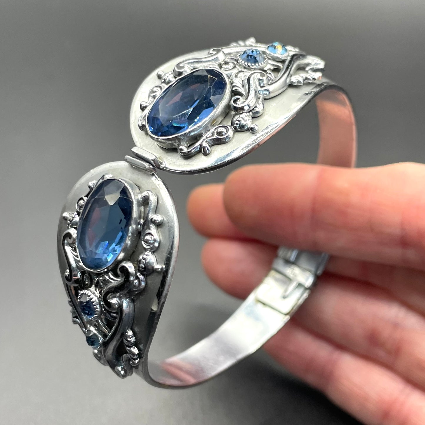 Vintage Neiger brothers sapphire blue rhinestone ornate Art Deco hinged clamper bangle set in silver tone with black enamel accents