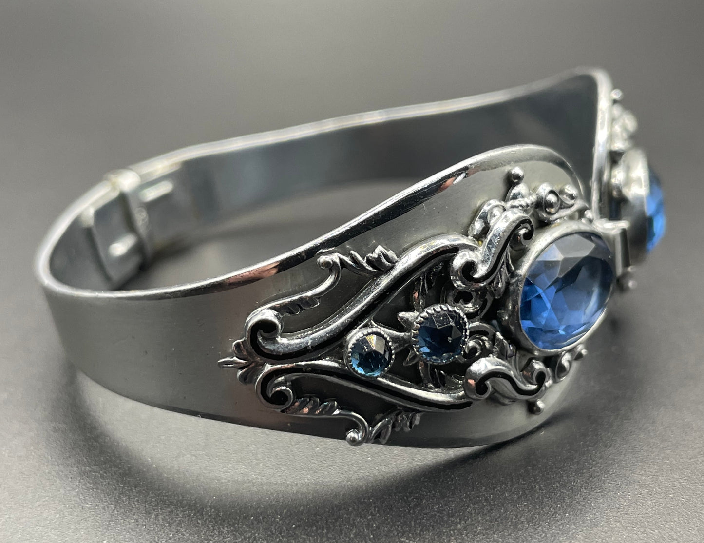 Vintage Neiger brothers sapphire blue rhinestone ornate Art Deco hinged clamper bangle set in silver tone with black enamel accents