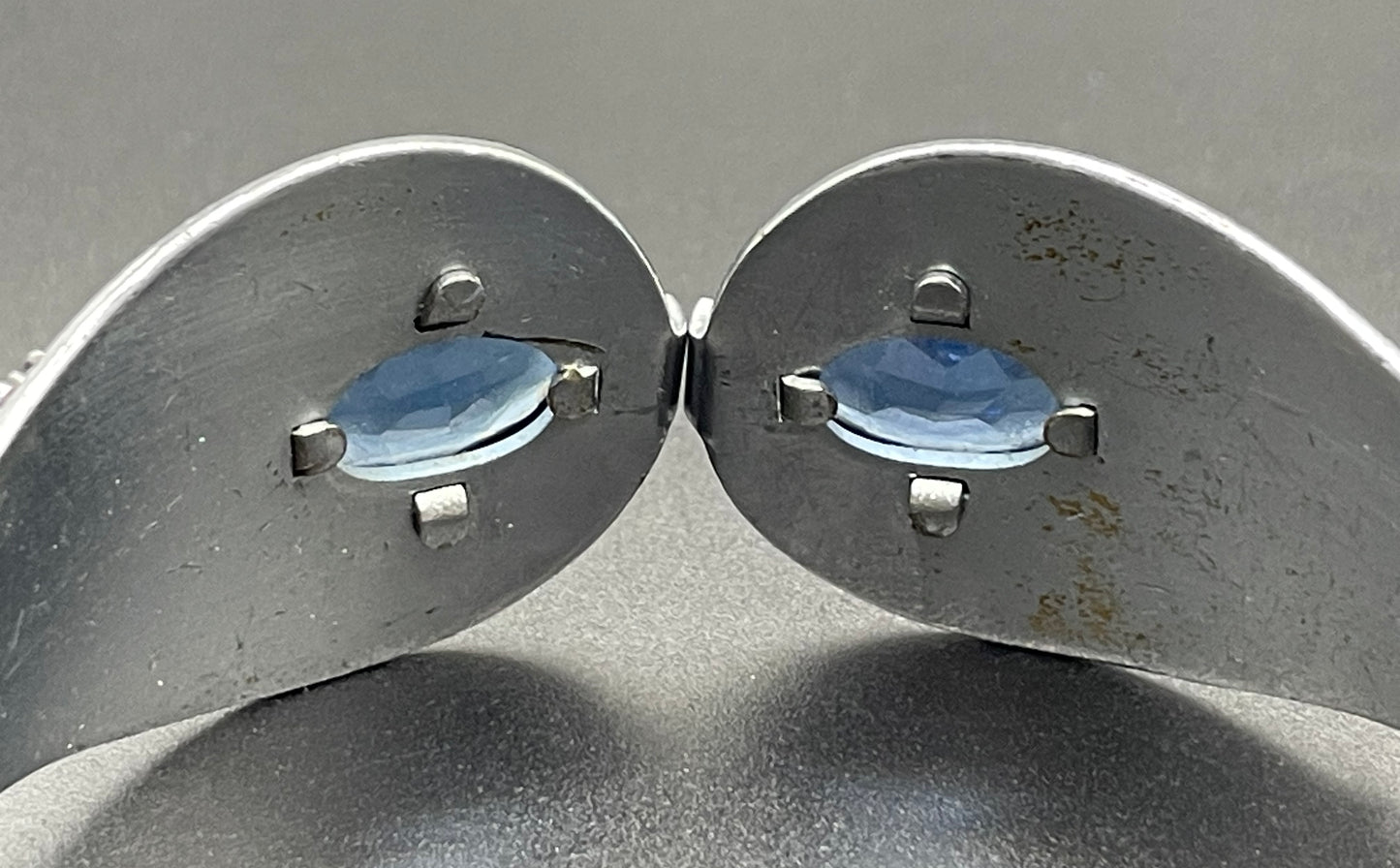 Vintage Neiger brothers sapphire blue rhinestone ornate Art Deco hinged clamper bangle set in silver tone with black enamel accents