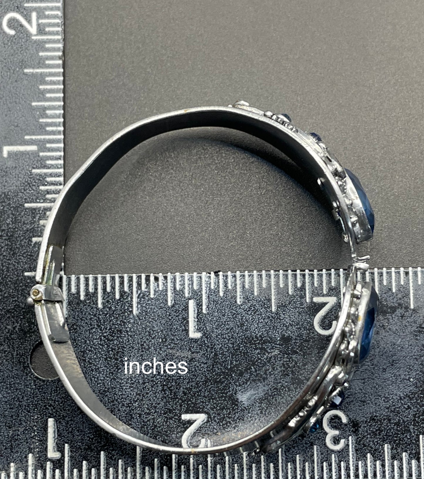 Vintage Neiger brothers sapphire blue rhinestone ornate Art Deco hinged clamper bangle set in silver tone with black enamel accents