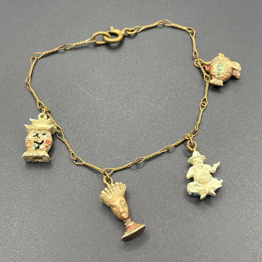 Delicate vintage / antique charm bracelet with slim gold tone chain and four early plastic or carved bone painted cracker charms