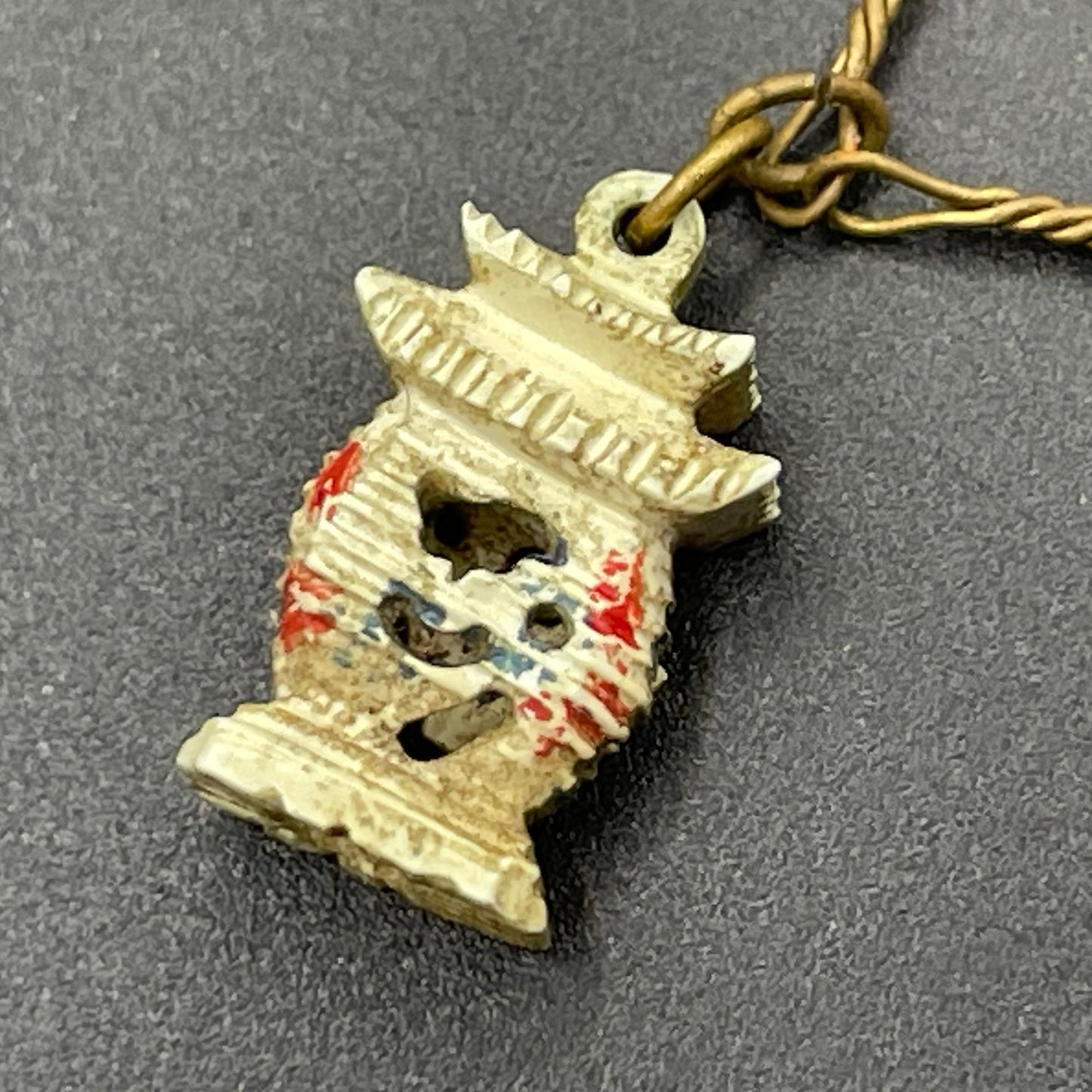 Delicate vintage / antique charm bracelet with slim gold tone chain and four early plastic or carved bone painted cracker charms