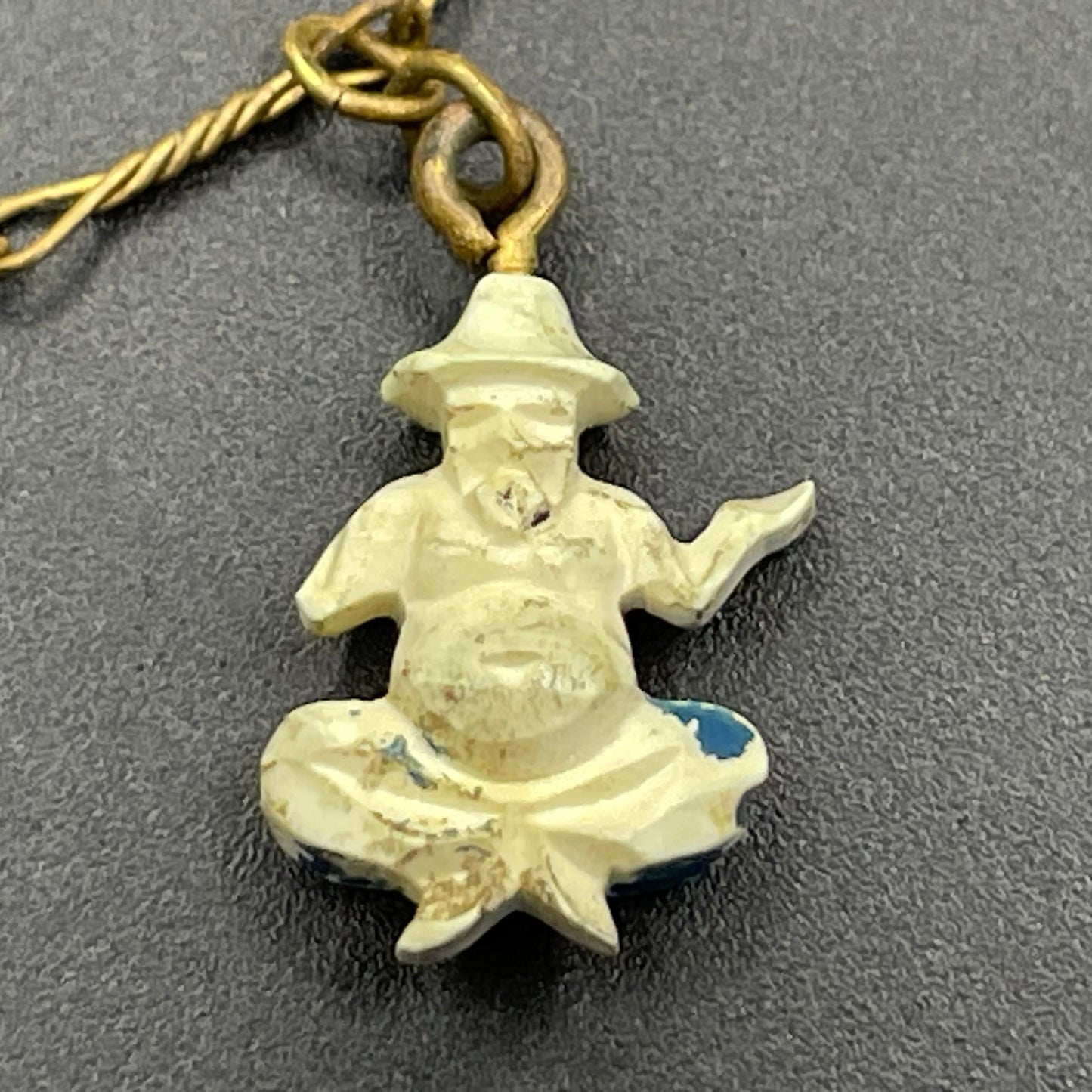 Delicate vintage / antique charm bracelet with slim gold tone chain and four early plastic or carved bone painted cracker charms