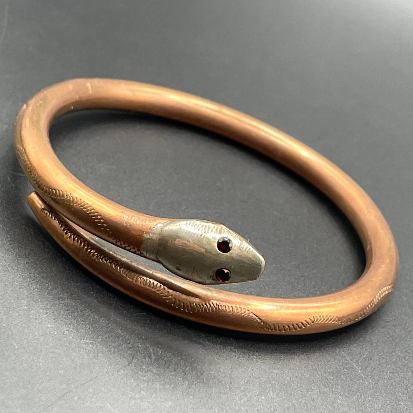 Vintage Art Deco 1920s to 1930s heavy copper snake arm bangle with silver tone head and garnet eyes, pretty hand engraving / tooling
