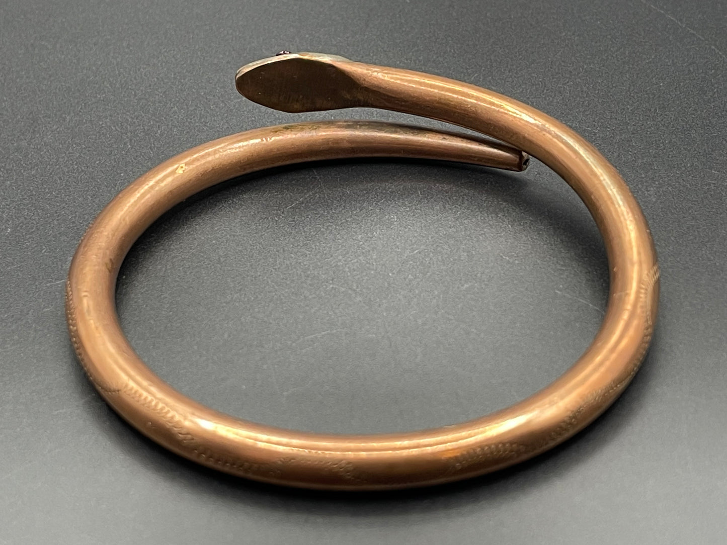 Vintage Art Deco 1920s to 1930s heavy copper snake arm bangle with silver tone head and garnet eyes, pretty hand engraving / tooling