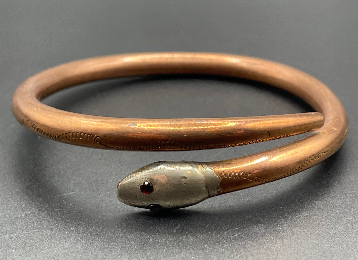 Vintage Art Deco 1920s to 1930s heavy copper snake arm bangle with silver tone head and garnet eyes, pretty hand engraving / tooling