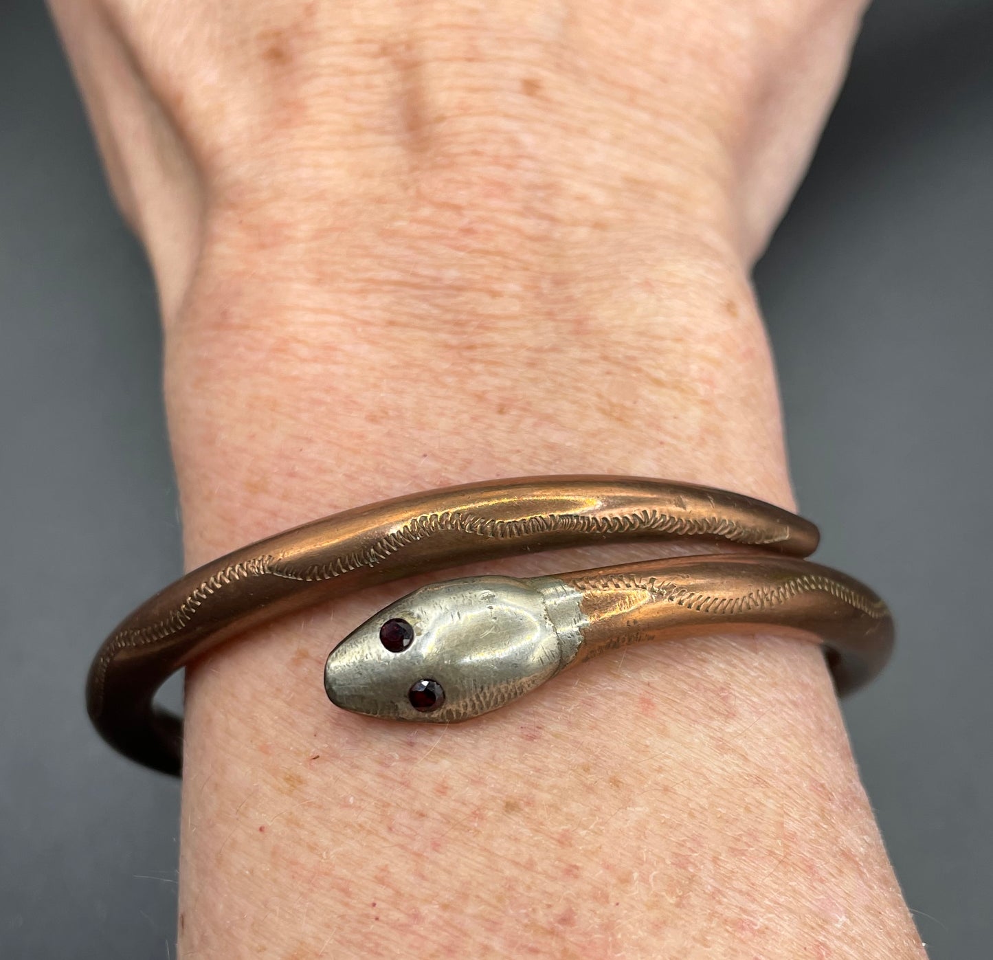 Vintage Art Deco 1920s to 1930s heavy copper snake arm bangle with silver tone head and garnet eyes, pretty hand engraving / tooling