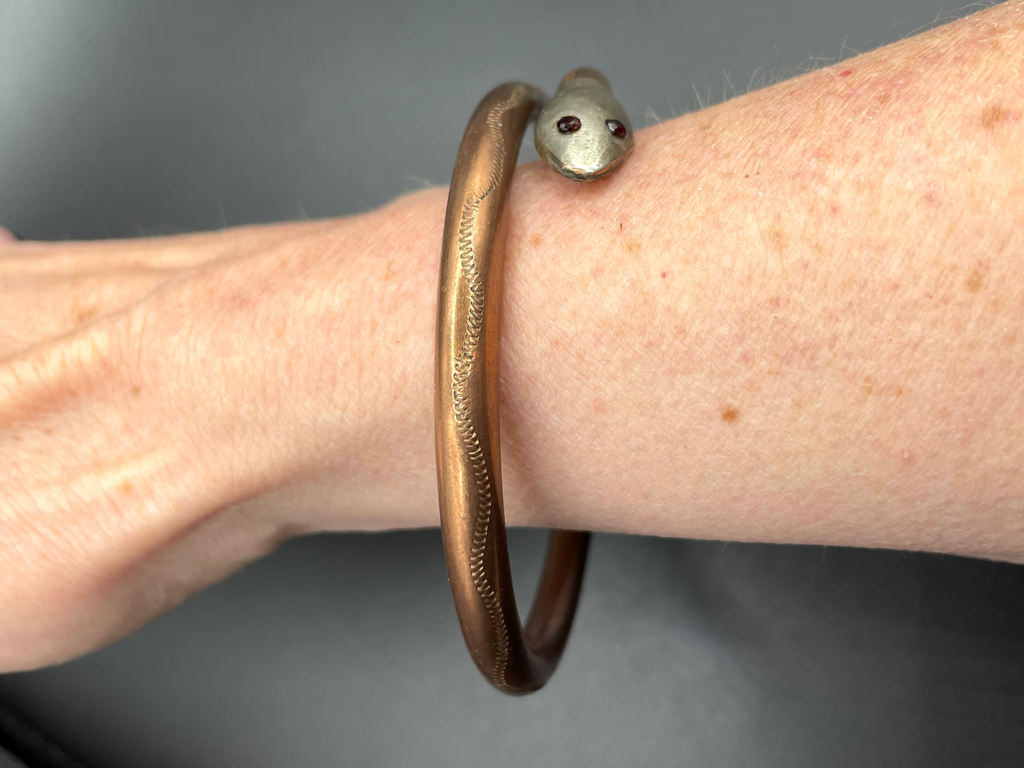 Vintage Art Deco 1920s to 1930s heavy copper snake arm bangle with silver tone head and garnet eyes, pretty hand engraving / tooling