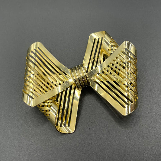 Vintage Art Deco machine age shiny gold tone stylised pierced metal geometric bow ribbon brooch, 1930s