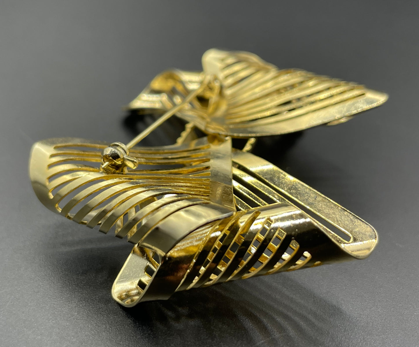 Vintage Art Deco machine age shiny gold tone stylised pierced metal geometric bow ribbon brooch, 1930s
