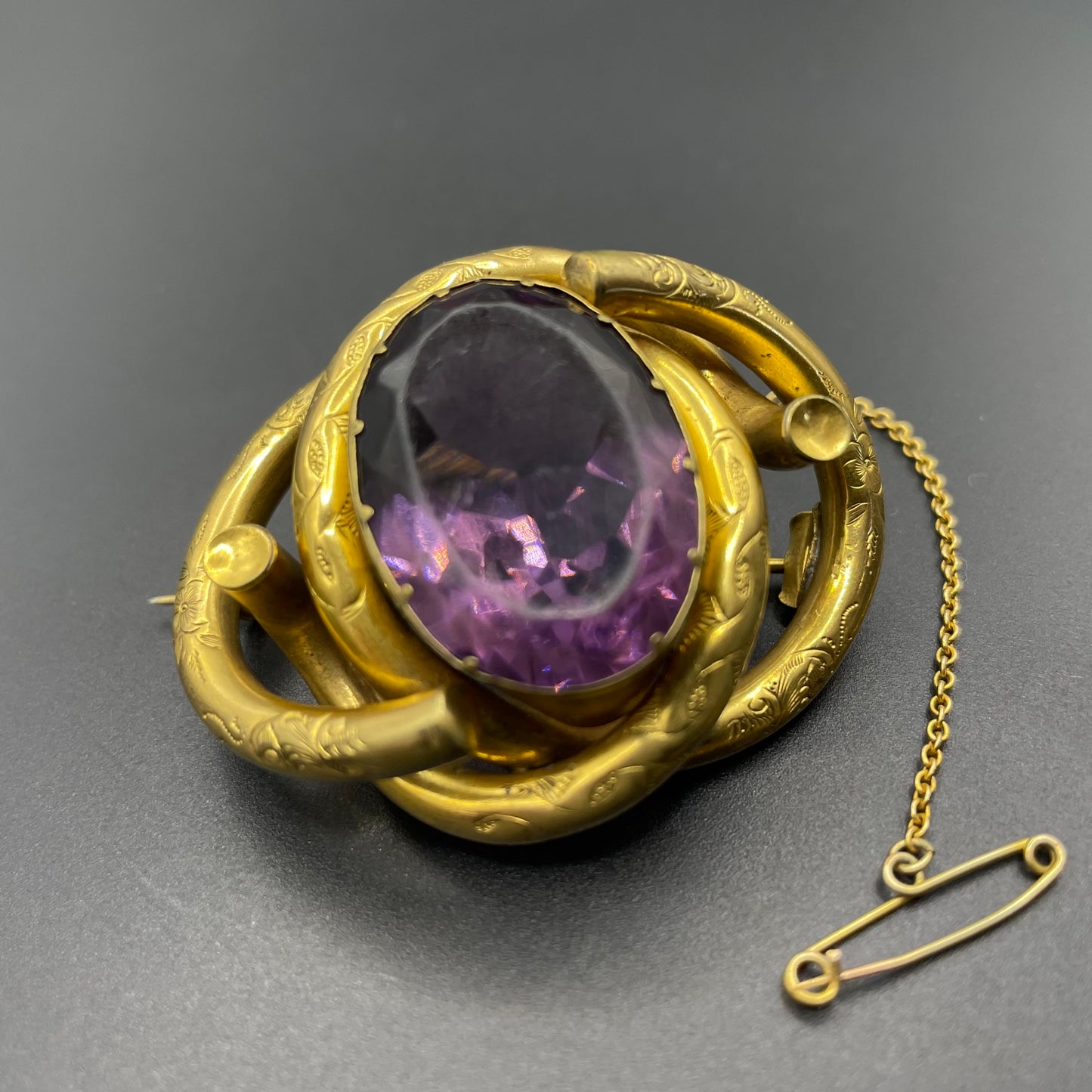 Antique Victorian Scottish chased pinchbeck or gold filled / rolled gold large love knot brooch with large purple paste rhinestone