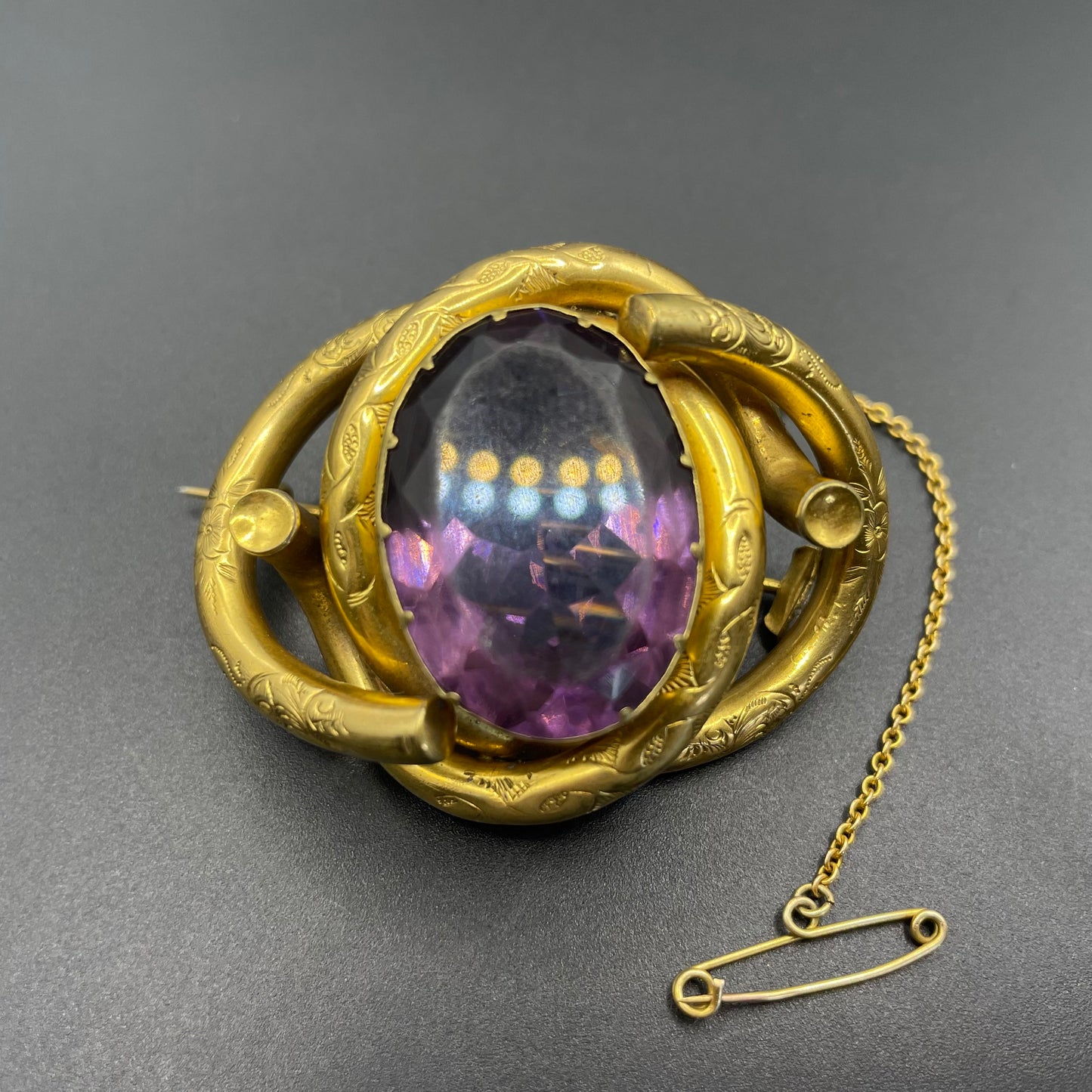 Antique Victorian Scottish chased pinchbeck or gold filled / rolled gold large love knot brooch with large purple paste rhinestone