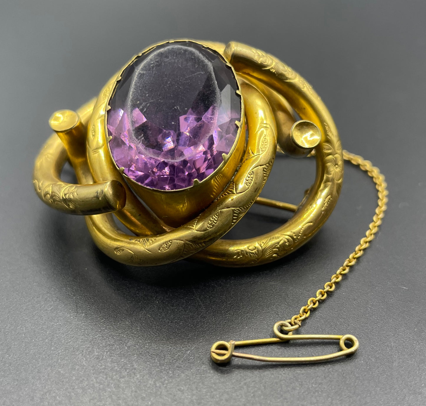 Antique Victorian Scottish chased pinchbeck or gold filled / rolled gold large love knot brooch with large purple paste rhinestone