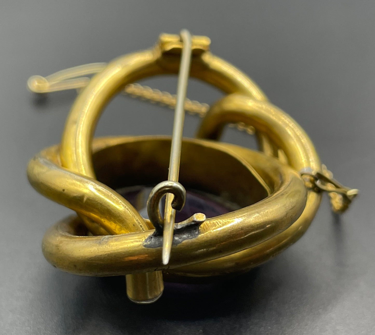 Antique Victorian Scottish chased pinchbeck or gold filled / rolled gold large love knot brooch with large purple paste rhinestone