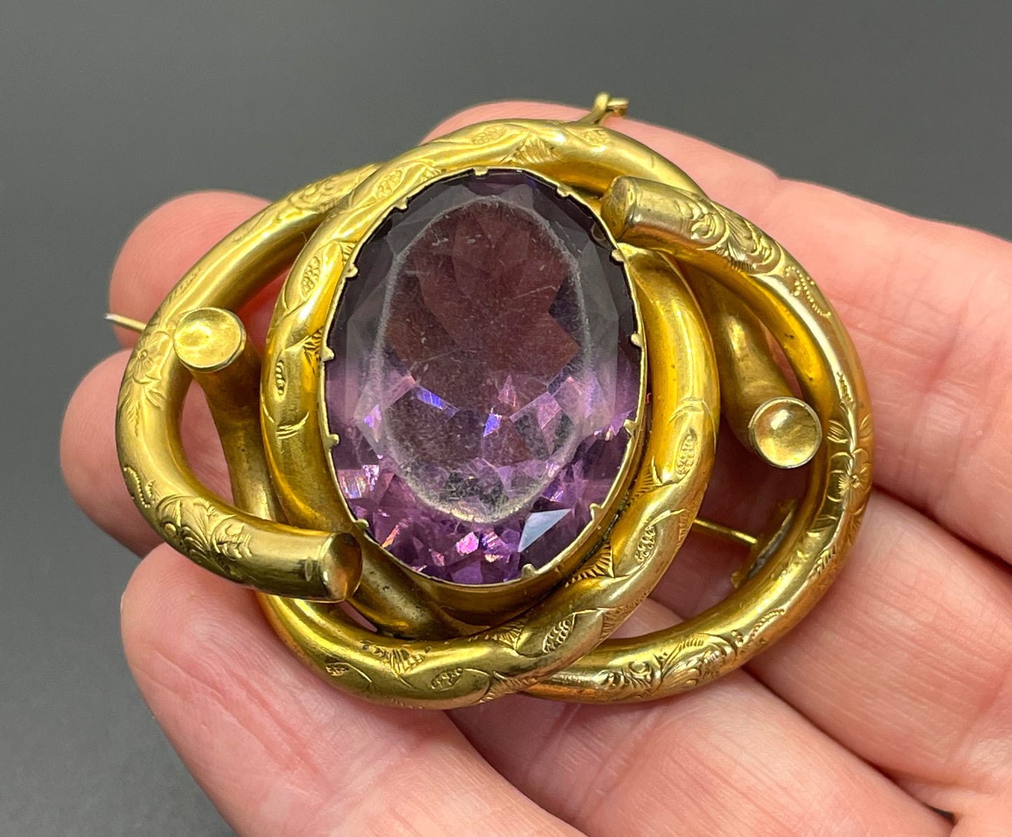 Antique Victorian Scottish chased pinchbeck or gold filled / rolled gold large love knot brooch with large purple paste rhinestone