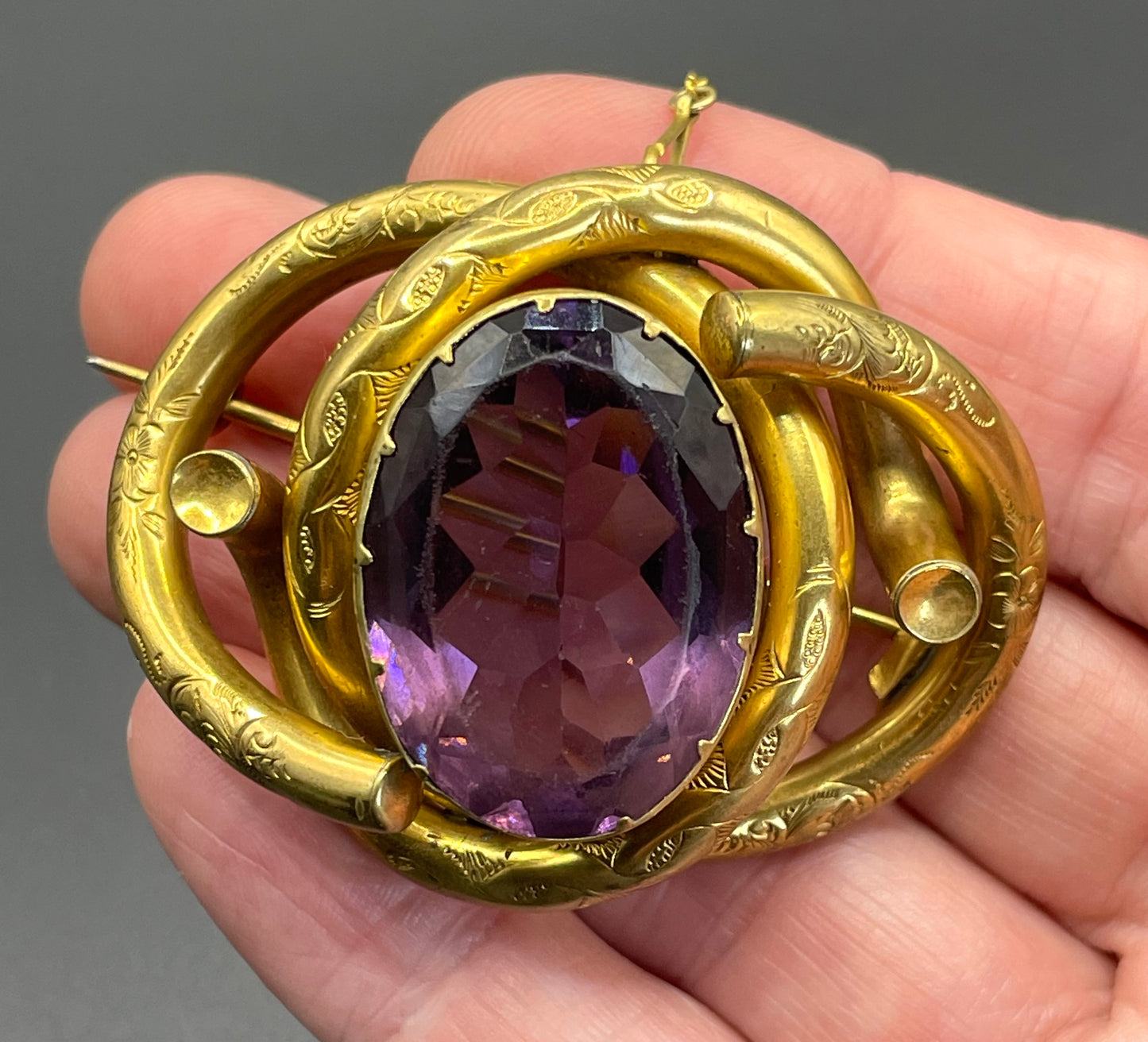 Antique Victorian Scottish chased pinchbeck or gold filled / rolled gold large love knot brooch with large purple paste rhinestone